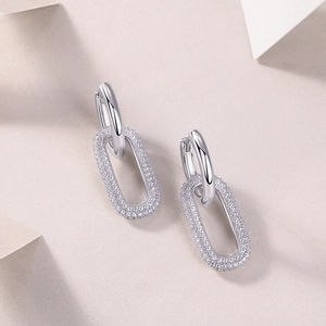 Macro shot of silver drop earrings with micro-paved moissanite on oval links
