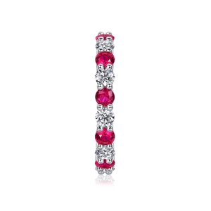Macro side view of silver ring with alternating red and white stones in prong setting