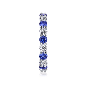 Detailed view of an eternity band ring with round-cut blue sapphires and white diamonds