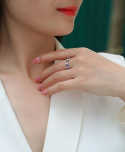 Detailed close-up of a S925 silver ring featuring blue sapphire and white diamonds on a finger