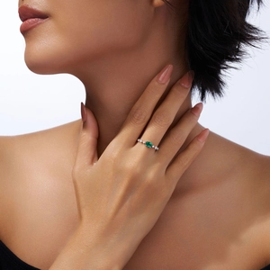 Gros plan détaillé d'une bague émeraude ovale avec diamants sur le doigt d'un mannequin