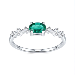 Vue macro d'une bague en argent S925 avec émeraude ovale et diamants latéraux