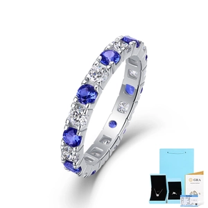 Dettaglio anello eternity in argento con pietre blu e bianche, astuccio e certificato