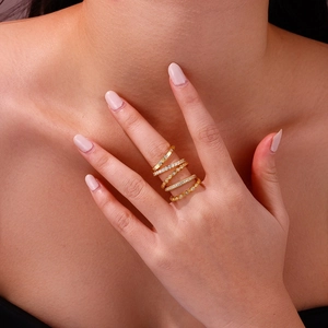 Detail of five-piece gold plated stacking ring set with cubic zirconia on model's finger