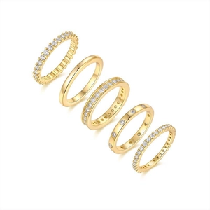 Detail of five stackable gold-plated rings with zircon pavé and minimalist bands