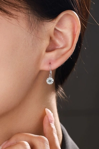 Close-up of a sterling silver drop earring with a brilliant round-cut moissanite stone