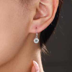 Elegant S925 sterling silver drop earrings with round moissanite stone worn by a model
