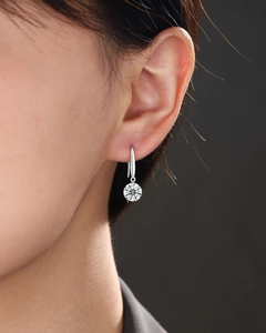 Gros plan d'une boucle d'oreille en moissanite couleur D sur un modèle en argent S925