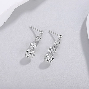Macro detail of S925 sterling silver drop earrings with three graduated moissanite stones