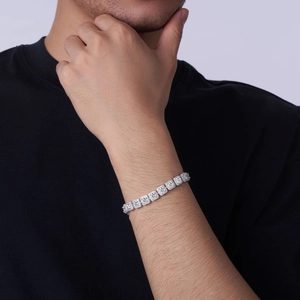 Detail of a square-cut tennis bracelet in sterling silver worn on a man's wrist