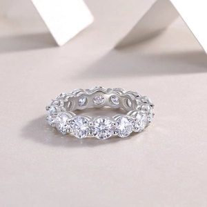 Macro shot of silver eternity ring with 5mm round moissanite stones and secure claw setting