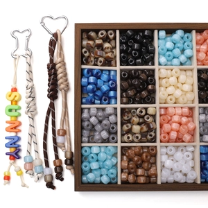 Top view of colorful resin pony beads in a wooden box with DIY keychain accessories