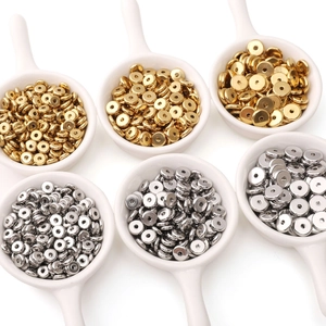 Gold and silver stainless steel flat round spacer beads displayed in ceramic spoons