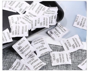Macro shot of multiple white silica gel desiccant packets for jewelry moisture protection