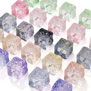 Detailed view of colorful square glass beads with floral engravings for DIY jewelry