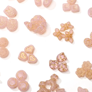 Pink translucent glass beads with gold accents in owl, butterfly, and heart shapes