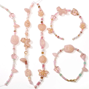 Pink glass bead jewelry set featuring butterfly and flower charms for DIY crafts