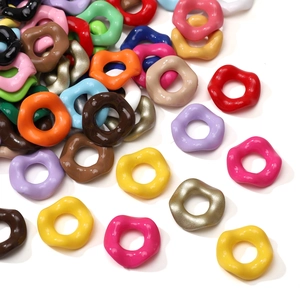 Vue macro de perles acryliques colorées en forme de vagues pour la création de bijoux