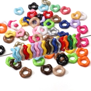 Perles festonnées colorées en acrylique pour bijoux DIY présentées sur une aiguille