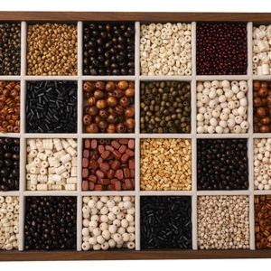 Detail view of various dark minimalist wooden beads in a grey velvet lined organizer box