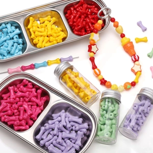 Colorful bone-shaped acrylic beads for DIY jewelry making displayed in metal trays