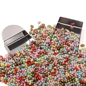 Macro shot of colorful peanut shaped two-hole beads with stainless steel bead scoops