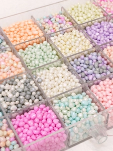 Macro di perline di vetro perlescenti irregolari in colori macaron in una scatola