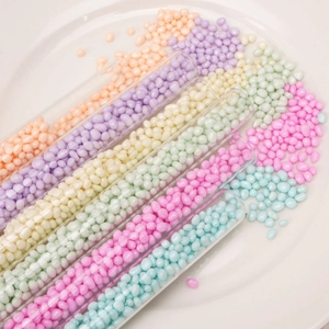 Perle irregolari in vetro macaron in provette su vassoio in ceramica per gioielli fai-da-te