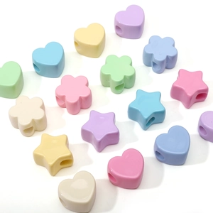 Dettaglio macro di perline acriliche macaron a forma di cuore e stella per gioielli