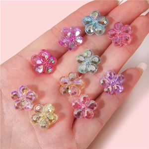 Iridescent acrylic flower beads in various colors held in hand for size reference