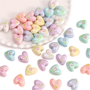 Macro-opname van hartvormige acryl tulpkralen met iriserende glans voor DIY-sieraden