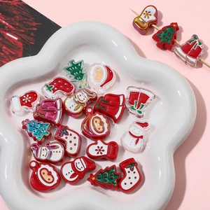 Close-up of Christmas acrylic beads with Santa and snowman on a white flower plate