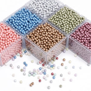 Detailed macro view of 4mm colorful glass pearl beads in a clear plastic storage organizer