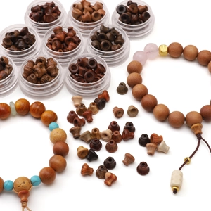 DIY wood beads in assorted tones organized in containers with finished beaded bracelets
