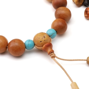 Macro view of brown wood beads with turquoise accents and a textured guru bead
