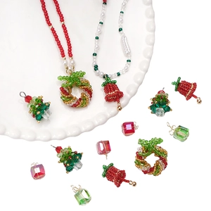 Detailed view of DIY Christmas glass bead charms including trees, bells and wreaths