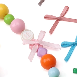 Macro shot of colorful polyester bows and assorted plastic beads for handmade jewelry DIY