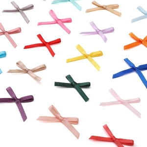 Detailed view of colorful mini polyester ribbon bows for DIY jewelry and crafts