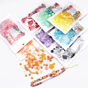 Détail d'un kit de perles DIY avec perles alphabet, breloques en argile et fils élastiques