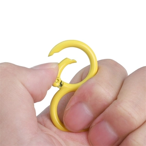 Close-up of yellow S-shaped carabiner clip being opened by hand for DIY accessories