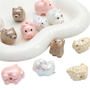 Vista macro di perle assortite in acrilico con animali in un vassoio bianco a cuore