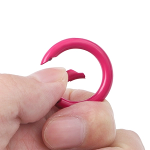 Close-up of rose red alloy round spring ring showing the flexible opening mechanism