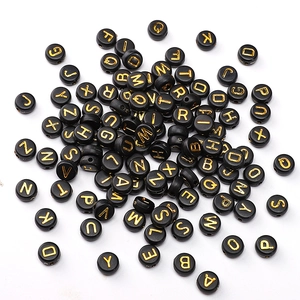 Close-up of 4x7mm black acrylic flat round beads with gold letters for DIY jewelry