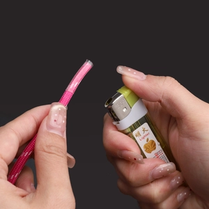 Pink braided rope with transparent heat shrink tubing being sealed by lighter flame
