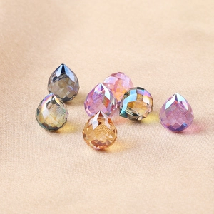 Vue macro de perles en verre facettées irisées pour bijoux DIY sur tissu de soie
