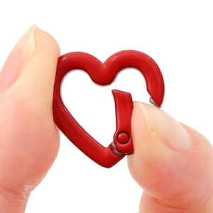 Gros plan d'un petit fermoir à ressort rouge en forme de cœur pour bijoux DIY