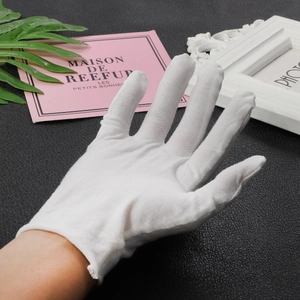 White cotton gloves for jewelry making and anti-oxidation handling on black background