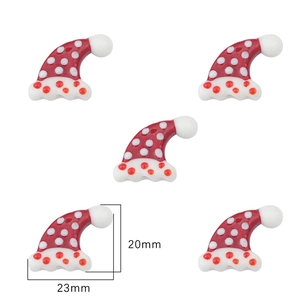 Macro view of Santa hat glass charms with white polka dots for DIY jewelry crafts
