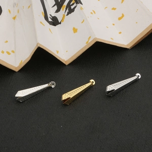 Makroaufnahme von konischen Metallanhängern in Gold und Silber für DIY-Schmuckherstellung