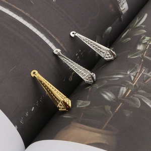 Makro-Detail von kegelförmigen Metallanhängern mit Wellenprägung für DIY-Schmuck